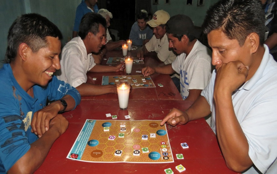 Atzeca chess game Men sit at a row of tables playing a board game