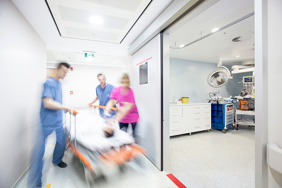 Hectic work Blurry photo of doctors and nurses wheeling a patient on a gurney in a hospital