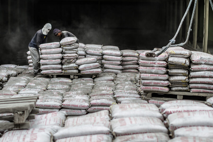 Invisible emitter Photo shows workers loading bags of cement mix in the Philippines.