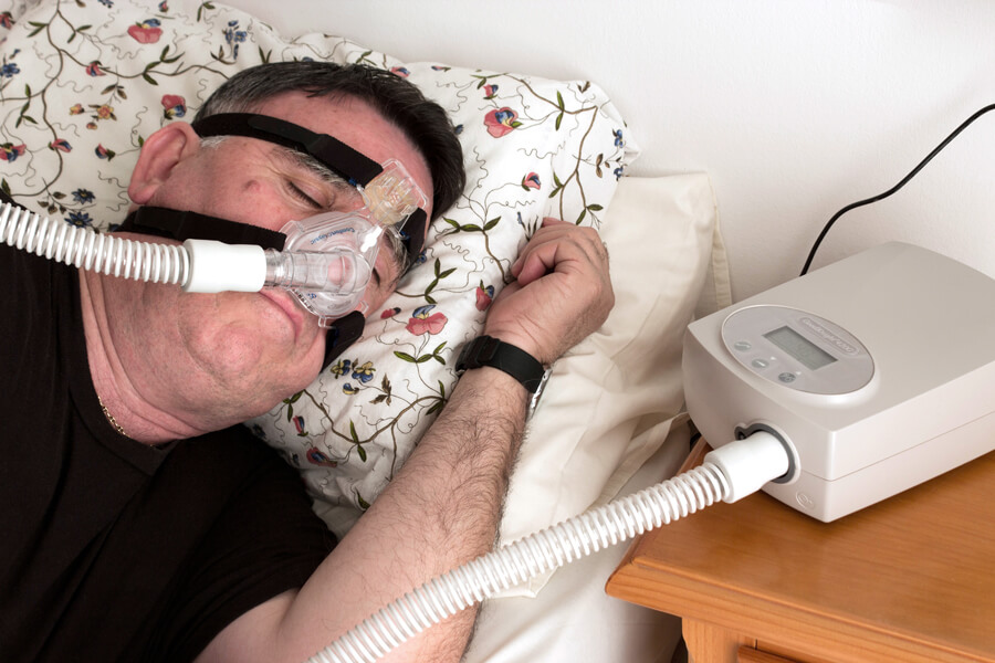 CPAP user Man wearing CPAP machine as he sleeps