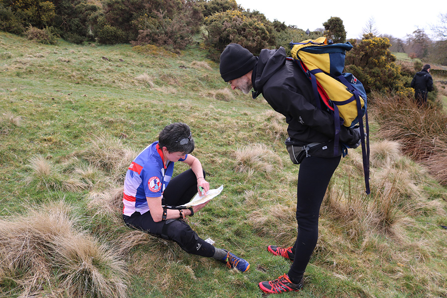 Orienteering Two people peer at a map in a wilderness setting