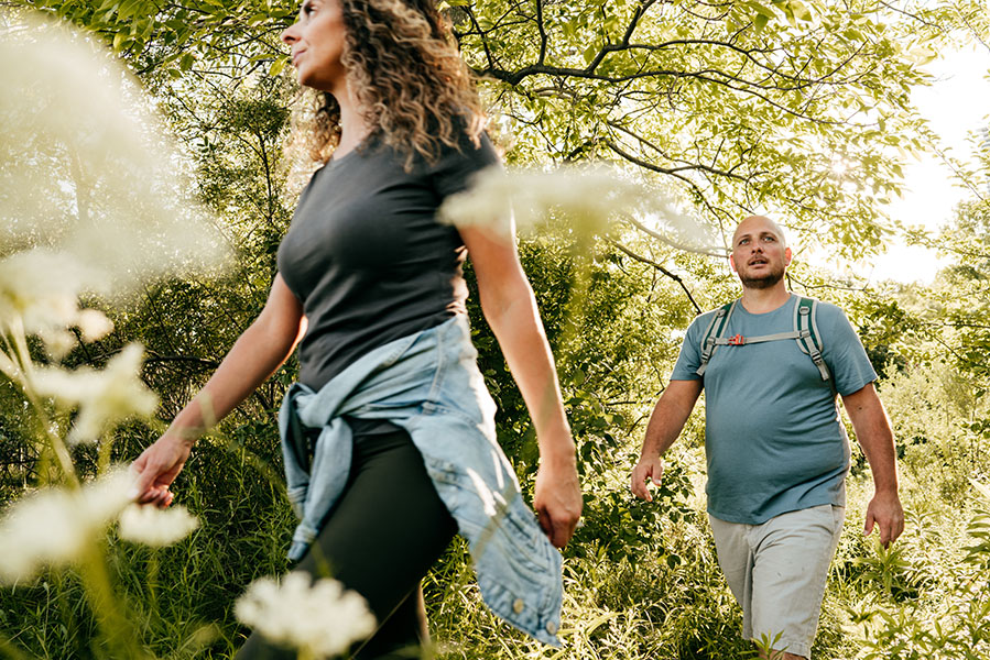 Exercise and prediabetes A fit-looking woman and an overweight man walk through the woods.