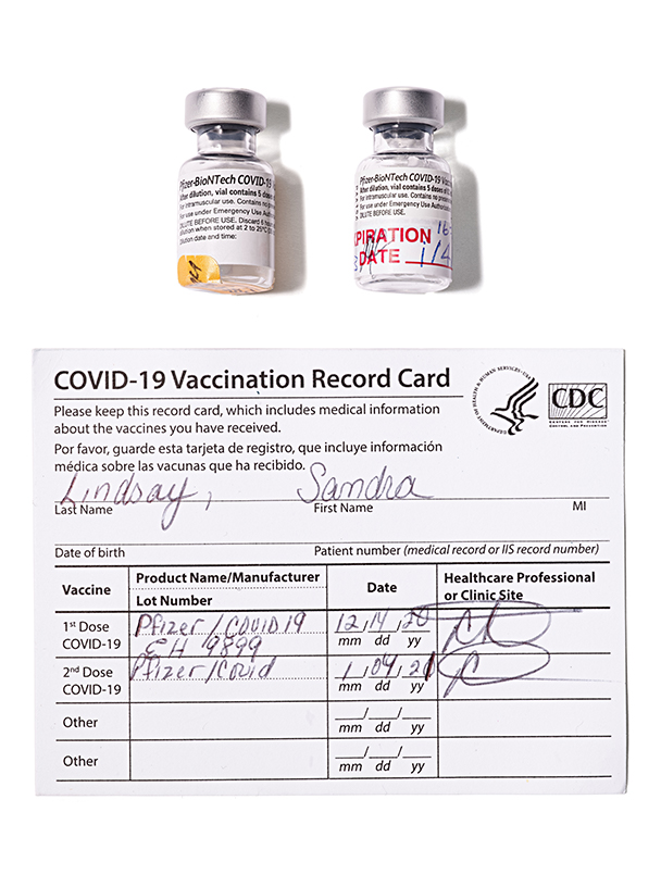 First US Covid vaccine A photograph shows two small vaccine vials and the vaccine card for Sandra Lindsay, filled out with the dates of her two vaccine doses.