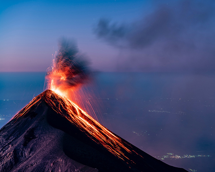 Fuego Volcano An erupting volcano, with lava spurting from its crater.